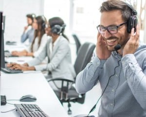 Smiling customer service executive with a headset working in a call center